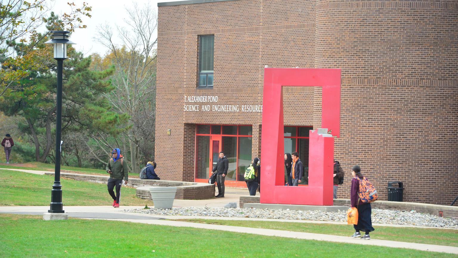 Students near Split and Twisted sculpture at the Science and Engineering Resource Center building on the Busch Campus