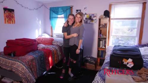 Two students stand in their decorated dorm room