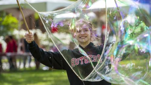 A woman blows bubbles at Rutgers Day