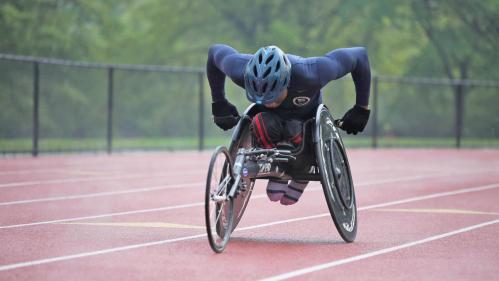 A student athlete using a wheelchair races on a track