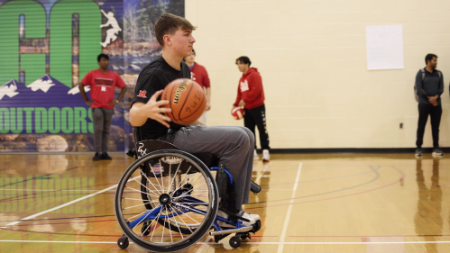 A player dribbles the ball during a game of wheelchair basketball.