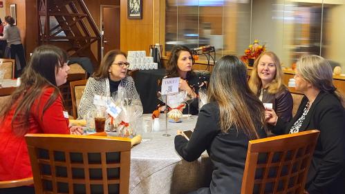 Research leaders sit at a round table and talk during a networking event