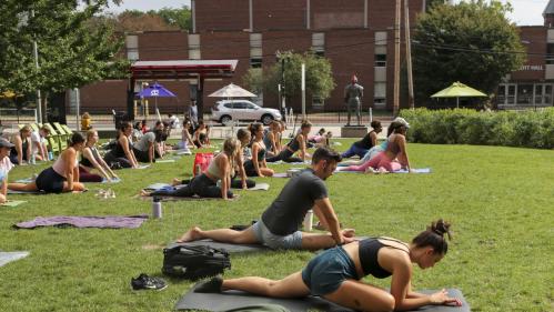 Students do yoga on the Yard outside during move-in week