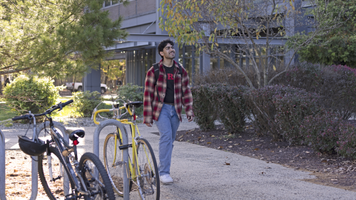A student walking on a path through campus