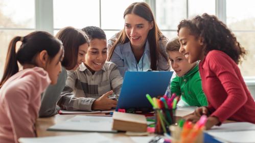 children in school being taught by a teacher