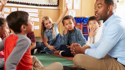 Teacher sitting down with a group of students