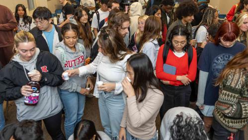 Students gather in a classroom drinking cranberry juice.