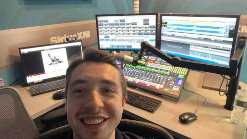 Rutgers senior Eddie Kalegi sits in front of a radio board at SiriusXM's headquarters in New York.