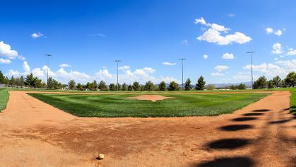 A baseball field under a bright blue sky