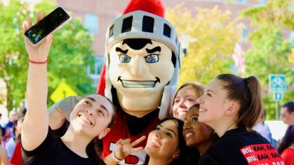 Students take a selfie with the Scarlet Knight mascot at the Involvment Fair