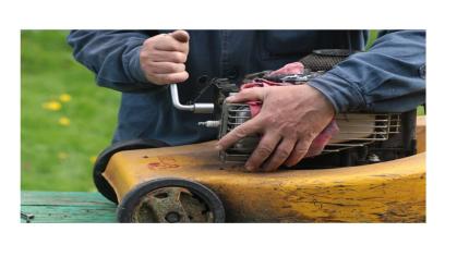 Hands fixing lawn mower motor
