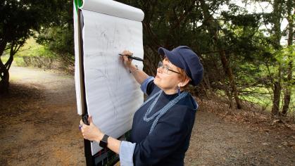 Student draws on canvas outdoors