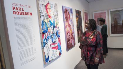 A woman looks at artwork honoring Paul Robeson in the Zimmerli Art Museum