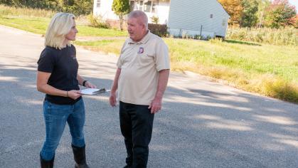 Brooke Maslo speaks with the director of Public Works for Woodbridge Township in front of a reclaimed house in Woodbridge