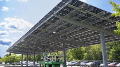 Solar canopies are being installed over a parking lot on campus