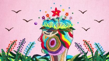 An embroidered image of a human mind sprouting flowers and plants.