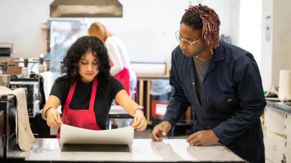 An image of an instructor overlooking a students portfolio work