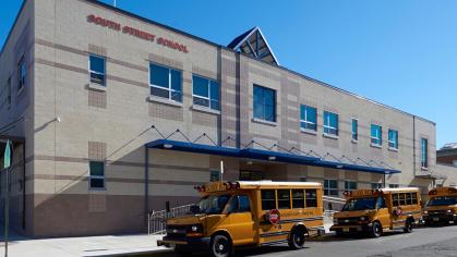 The South Street School building in Newark with buses parked out front.