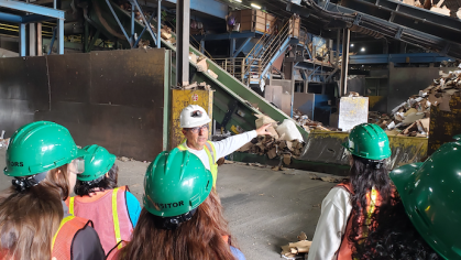 Students listening to a worker at the Colgate Recycling Center discuss sorting and recovering packaging waste as part of a classroom enrichment activity for their Sustainable Packaging course