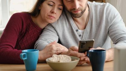 A romantic couple who are looking at their phone