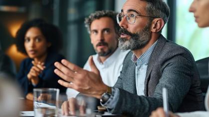 Male in a boardroom speaking to executives