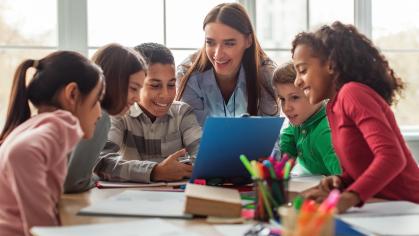 children in school being taught by a teacher