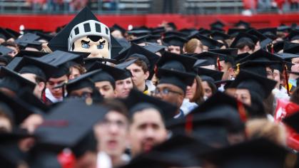 The Scarlet Knight in a crowd of graduates at Commencement