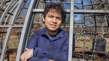 Rutgers student Mukhilan Saravanakumar stands inside playground equipment on Cook Campus.