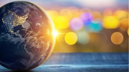 Globe of earth at left with sun sparkles to the right