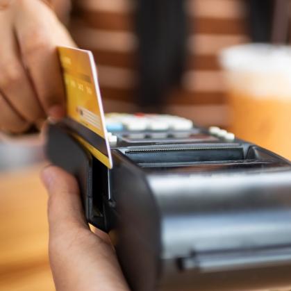 A student swipes a credit card to buy a coffee