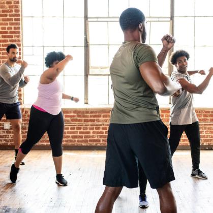 People wearing workout gear move their bodies in a workout class