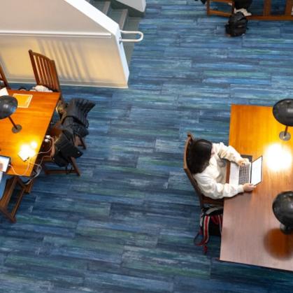 People seated at tables in the library, aerial view