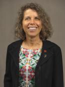 Vicki Banyard smiling and wearing a black blazer and a colorful blouse