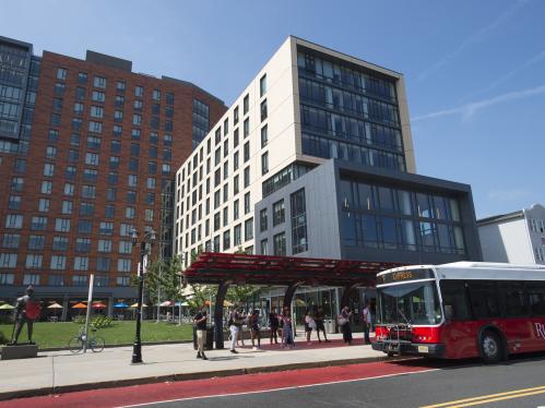 A Rutgers campus bus with campus buildings in the back drop