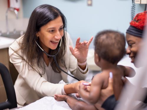 A doctor listens to an infant patient's heart with a stethoscope