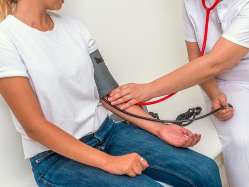 A nurse takes a student's blood pressure in an exam room