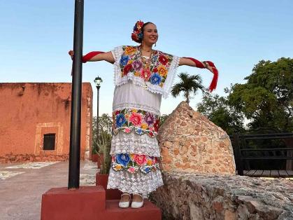 Alyssa McKendry – dressed in a terno, traditional formal attire in Yucatan – holds on to a light pole in the Mexican city of Tekax in May.