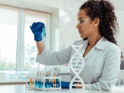 Woman in a lab coast holding a test tube in a lab setting