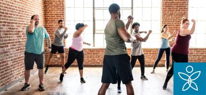 People wearing workout gear move their bodies in a workout class