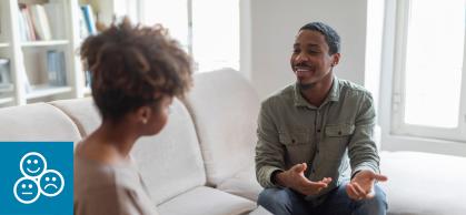 A student sits on a couch and talks with a counselor 