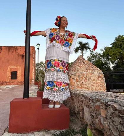 Alyssa McKendry – dressed in a terno, traditional formal attire in Yucatán – holds on to a light pole in the Mexican city of Tekax in May.