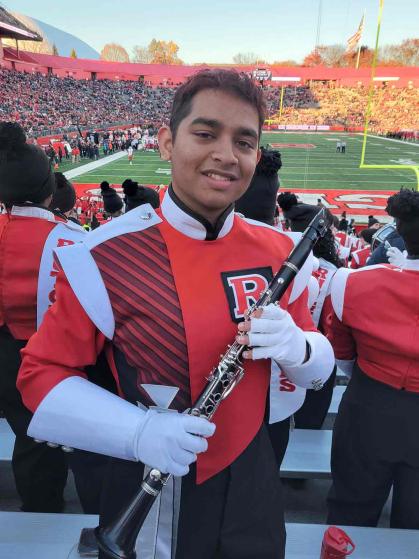 Mukhilan Saravanakumar, a member of the Rutgers University Marching Scarlet Knights, poses between performing at SHI Stadium.
