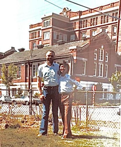 Man and boy stand in front of building