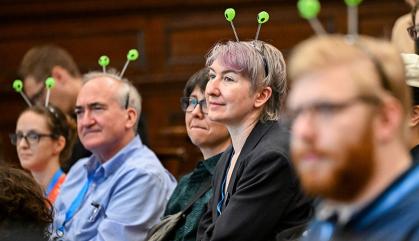 A group of scientists sit in an auditorium listening to speakers.