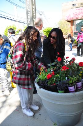 Francine Conway and student Olivia planting flowers outside of Student Activities Center on College Avenue Campus