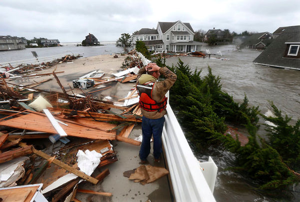A man looks onto a flooded neighborhood in Woodbridge after Superstorm Sandy