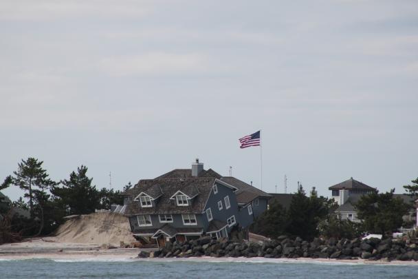 A toppled house sits on the beach after Superstorm Sandy
