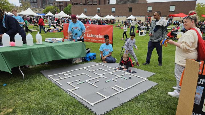 Students play with small toys on a track during Rutgers Day