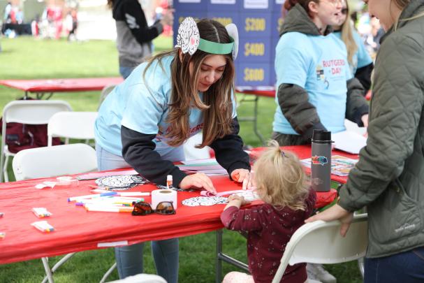A child stops at a program table on Rutgers Day