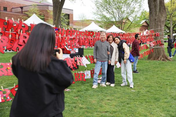 Attendees take a family photo in front of red R's on Rutgers Day